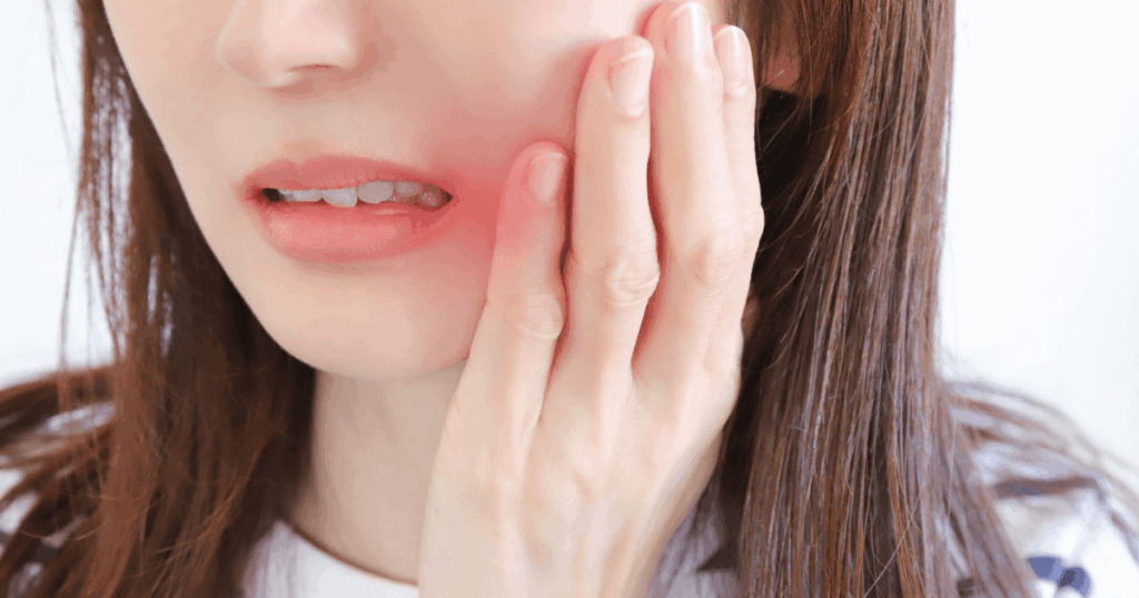 頬の腫れと痛みを感じる女性の口元