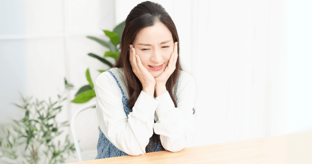 治療後に軽い痛みを感じて頬を押さえる女性