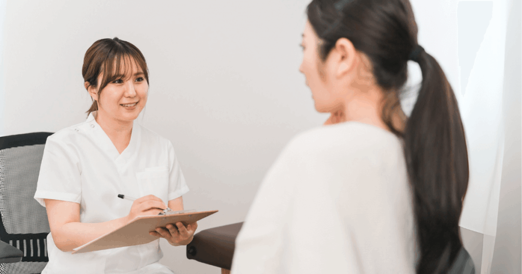 歯の痛みで歯科医院を受診し相談する女性