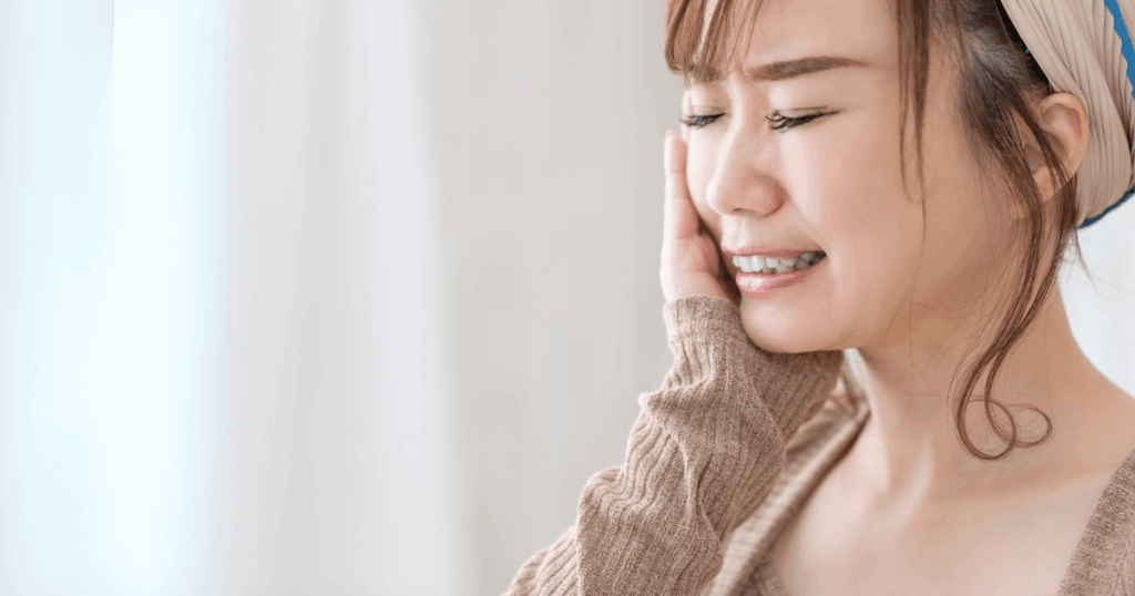 頬が腫れて痛みを感じる女性