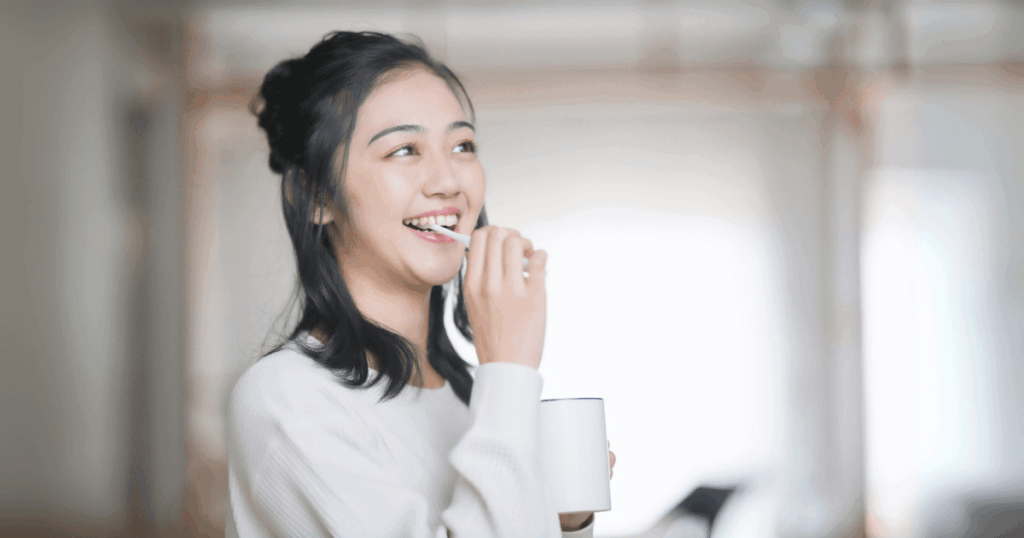 歯磨きをして笑顔を見せる女性の写真
