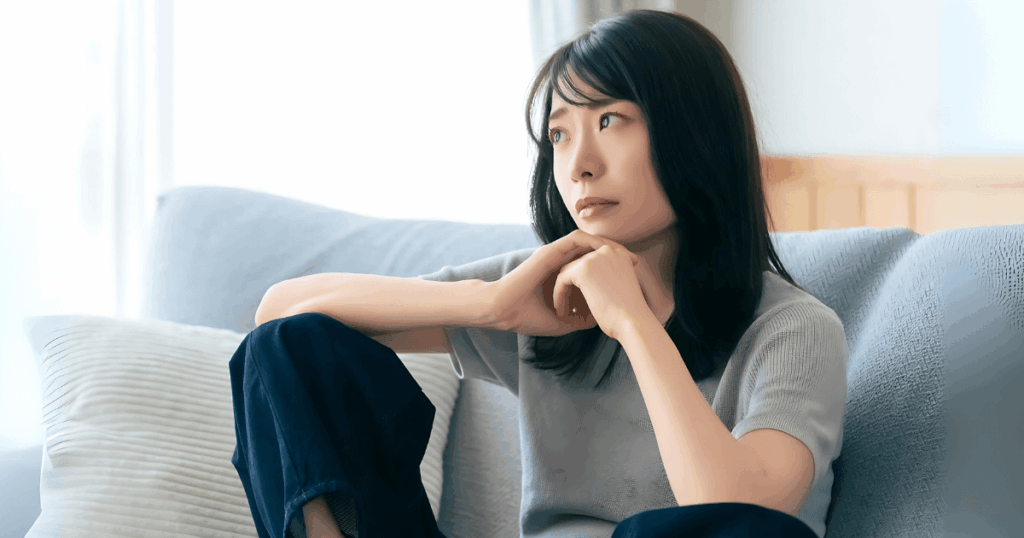 歯の神経を抜く治療を前に不安そうに考え込む女性