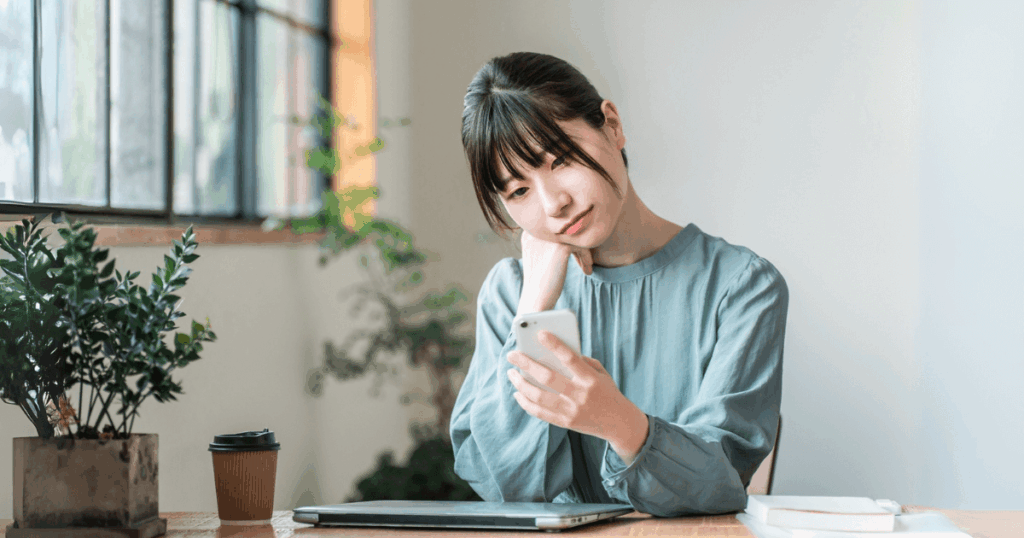 夜間や休日に受診できる歯科医院をスマホで探す女性