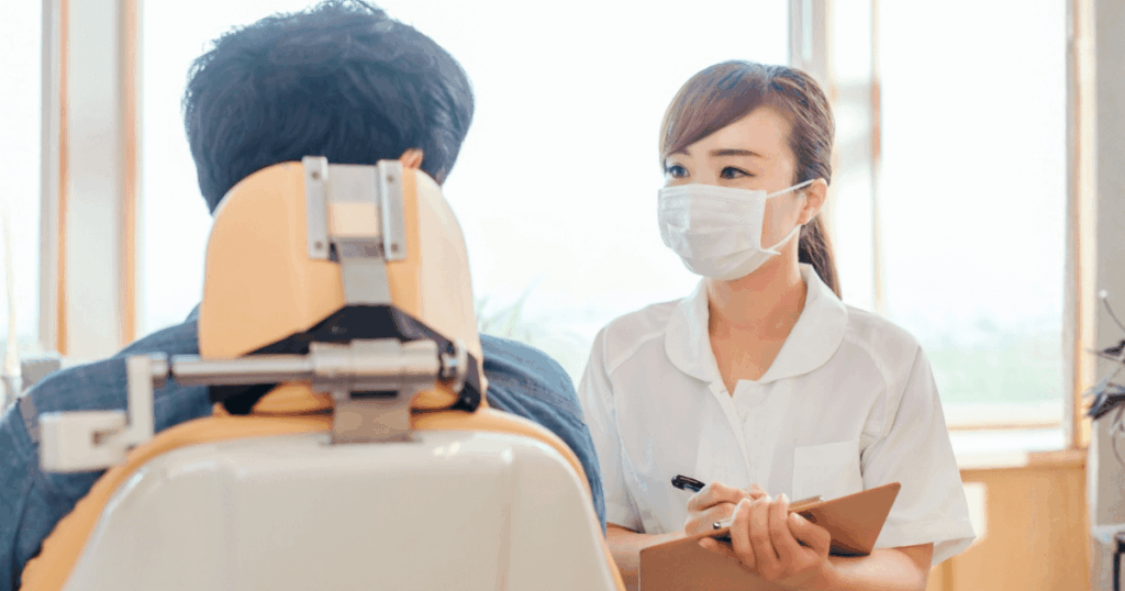 歯科医院で抜歯後の治療方法について相談する患者と歯科医師のイメージ