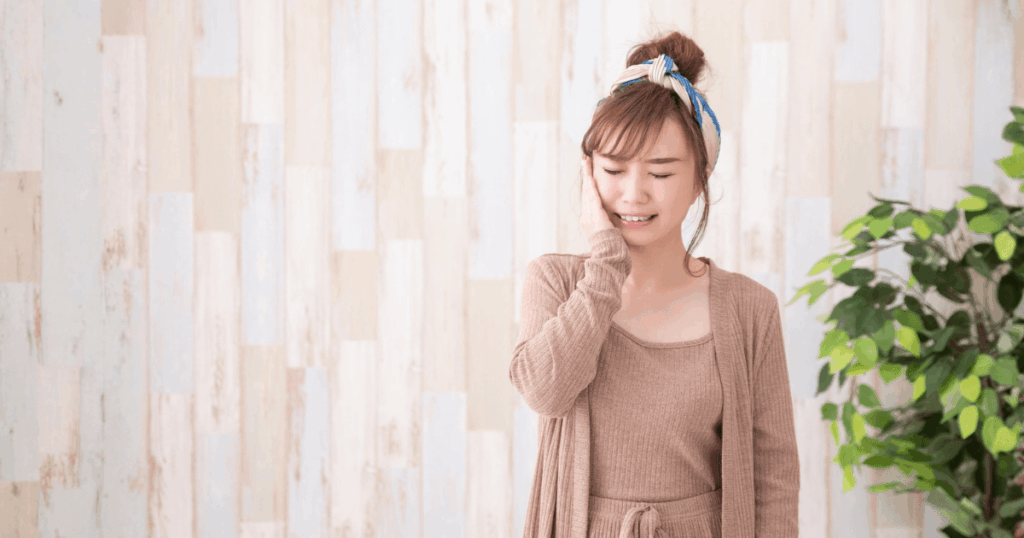 歯茎を押すと痛いのに腫れていない原因を調べる女性