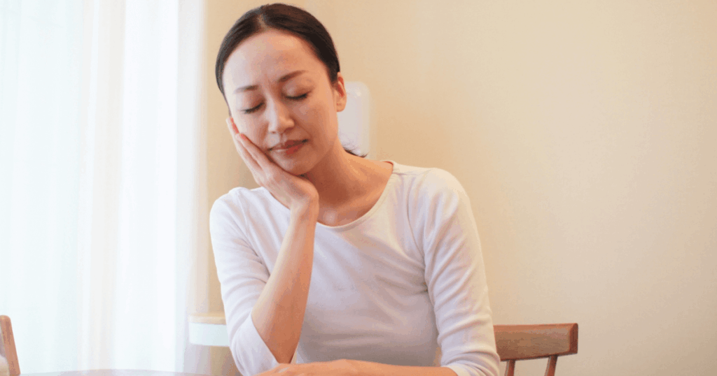 歯茎の痛みで歯医者の受診を検討する女性