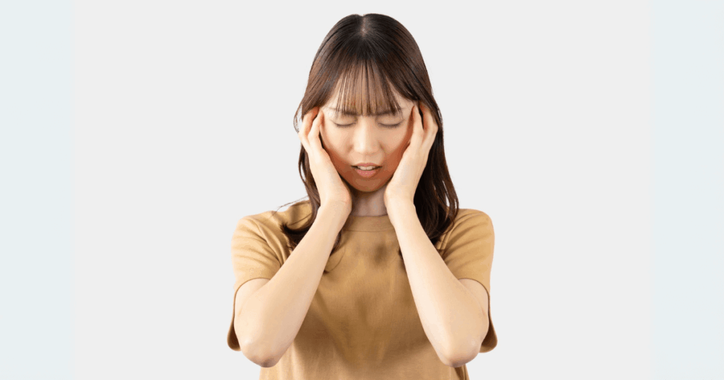 頭痛と歯の痛みを同時に感じる女性の写真