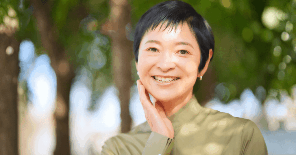 口元に手を添えて笑顔を見せる女性