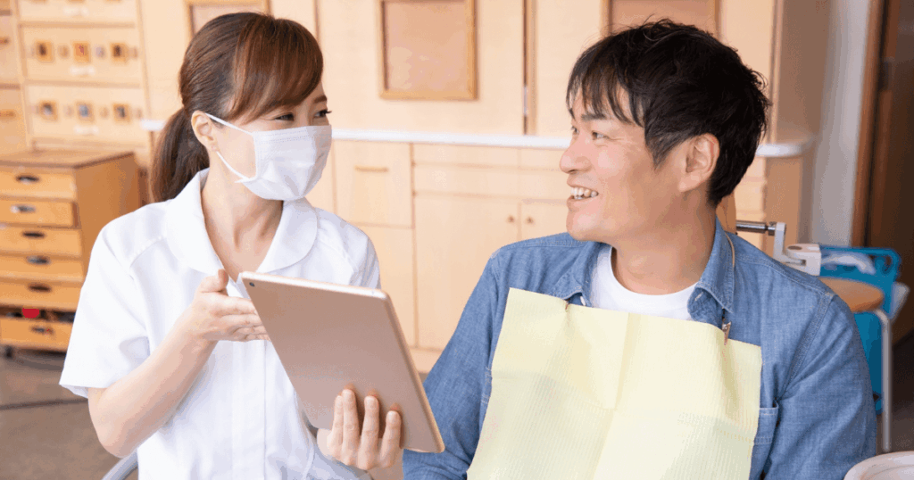 歯科医院で予防や生活習慣のアドバイスを受ける男性のイメージ