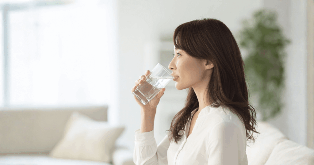 抜歯後のにおい対策として水を飲んで口の中を清潔に保つ女性
