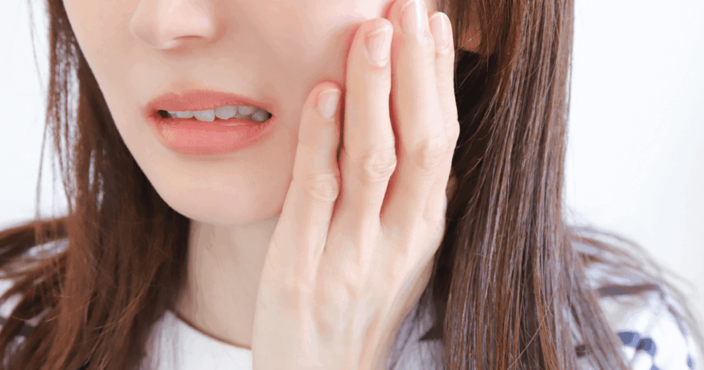 奥歯を押すと痛みを感じている女性のイメージ