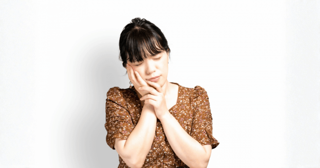 痛み止めが効かず頬を押さえてつらそうにしている女性