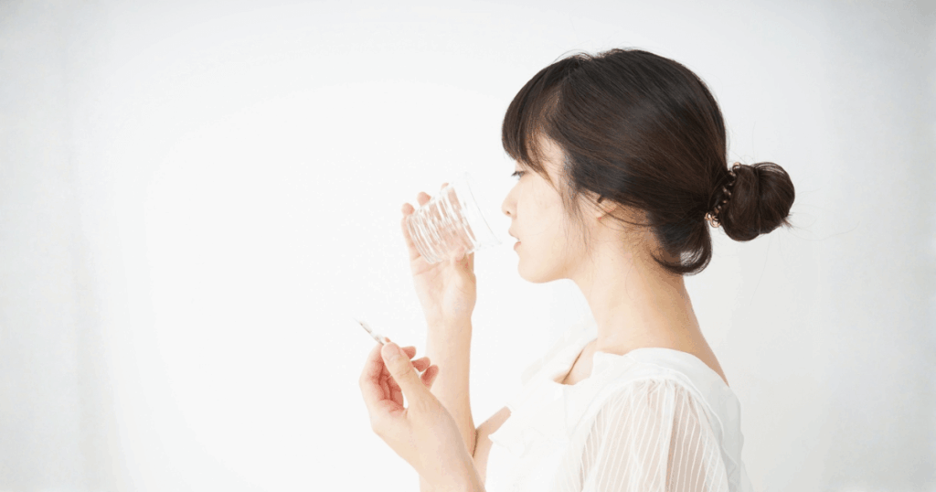 差し歯の痛みを和らげるために薬を飲む女性