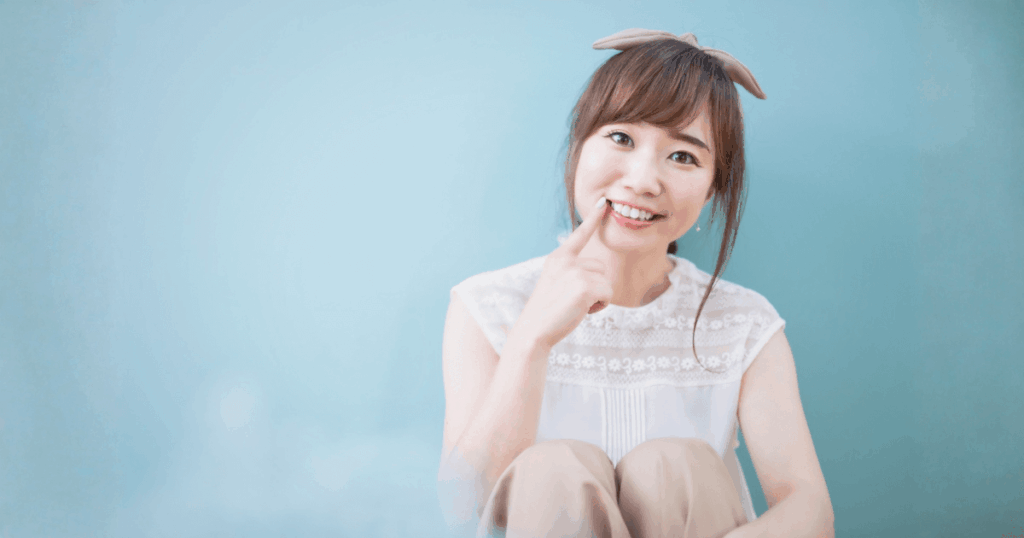 笑顔で歯を指さす女性
