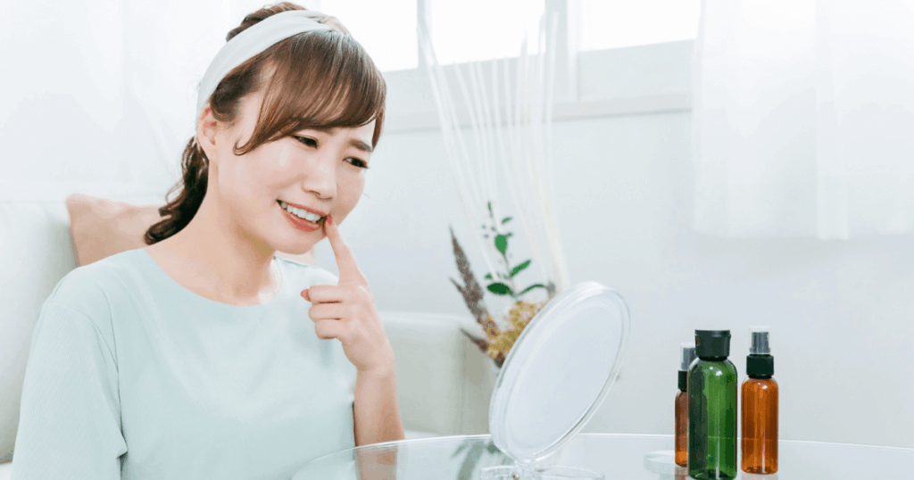 抜歯後の白い塊からのにおいが気になり口の中を確認する女性