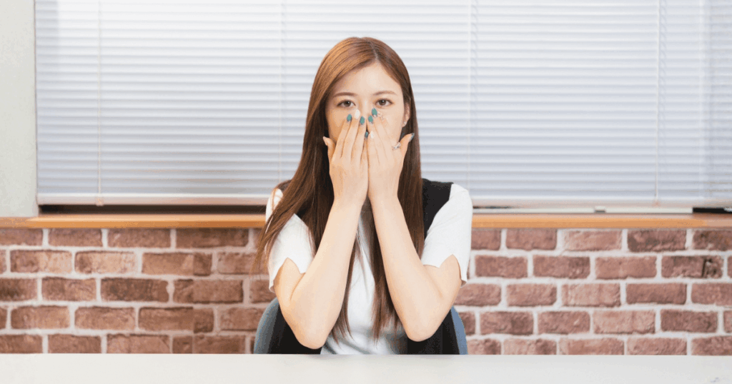 抜歯後に口の中の白いものや臭いが気になり、不安を感じている様子を表したイメージ画像