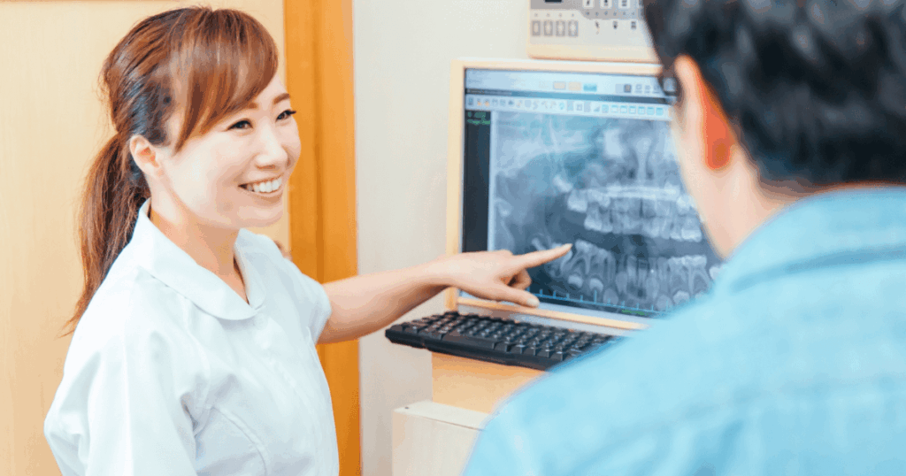 歯茎の腫れや膿について歯科医院で治療内容の説明を受けている診察シーンのイメージ画像