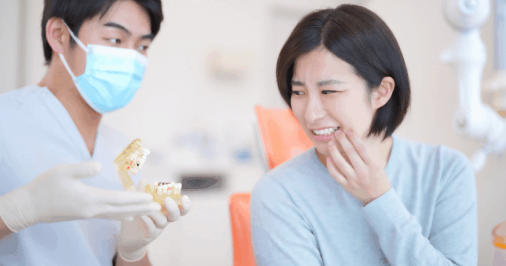 歯科医院で抜歯後の状態について説明を受け、口元を気にする女性の様子