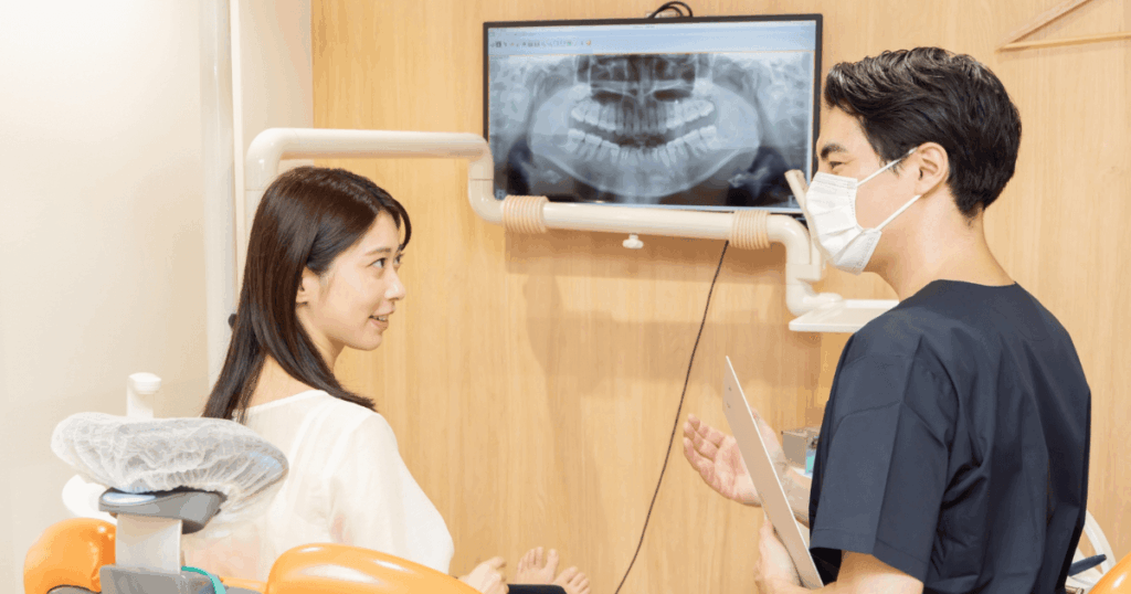 歯科医院で治療内容の説明を受ける女性の写真