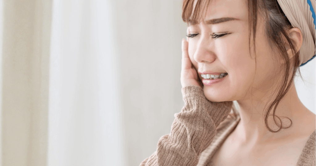 虫歯を治療せずに放置したことで、歯や口元に違和感が出ている女性のイメージ