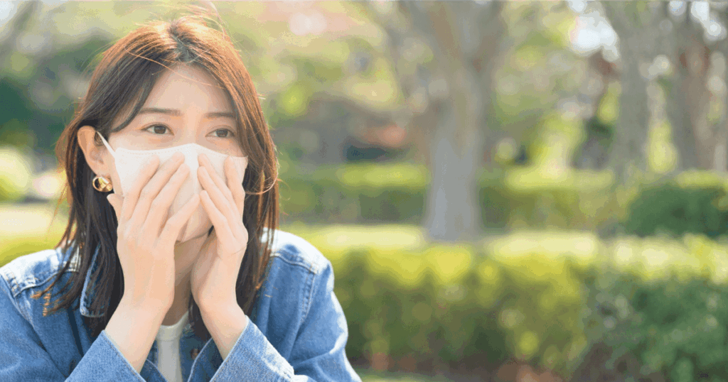 歯の痛みを心配して口元を押さえている女性の写真