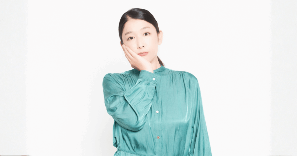 歯の状態に不安を感じて頬を押さえる女性の写真