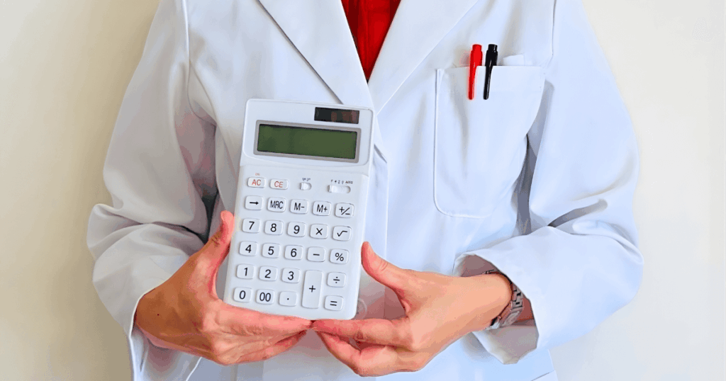 虫歯の抜歯にかかる費用をイメージした計算機を持つ歯科医師の画像