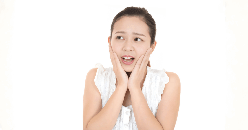 ひどい虫歯による抜歯の痛みを不安に感じている女性のイメージ画像