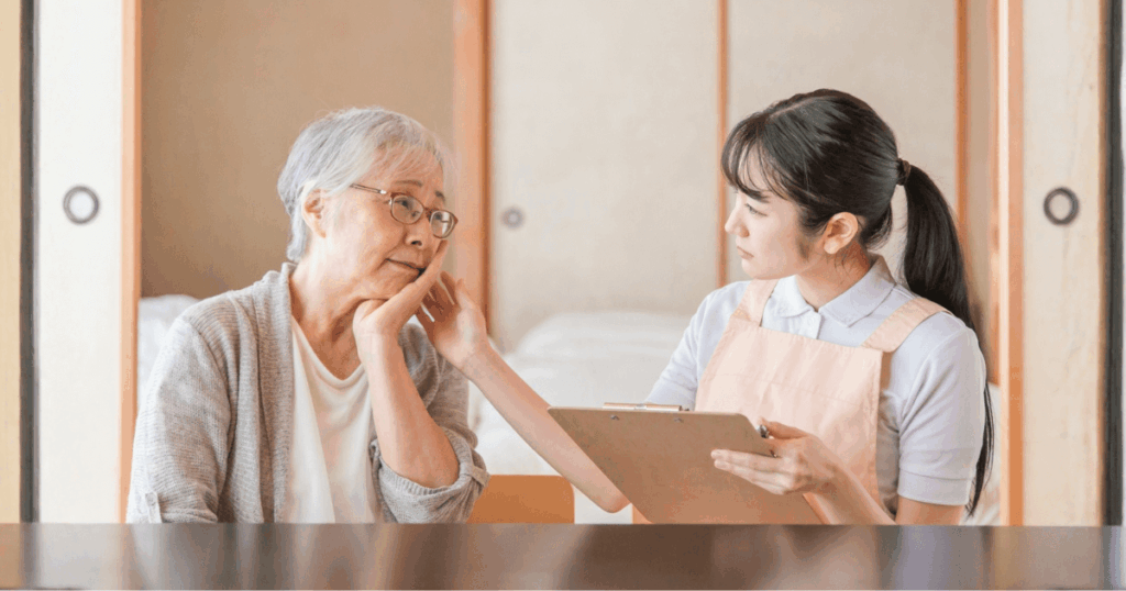 口の中の違和感について相談する高齢女性とスタッフ