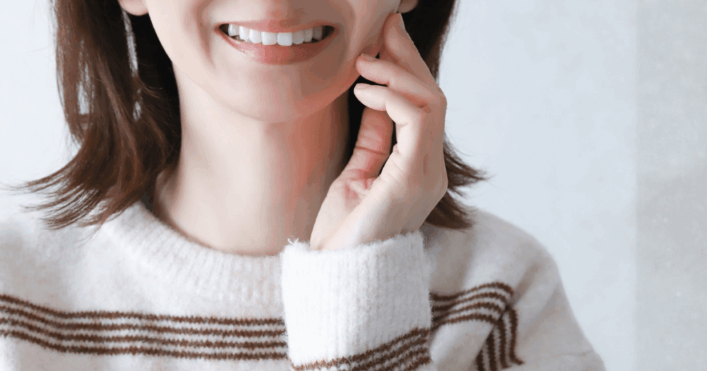 口元の不安がやわらぎ笑顔になった女性のイメージ