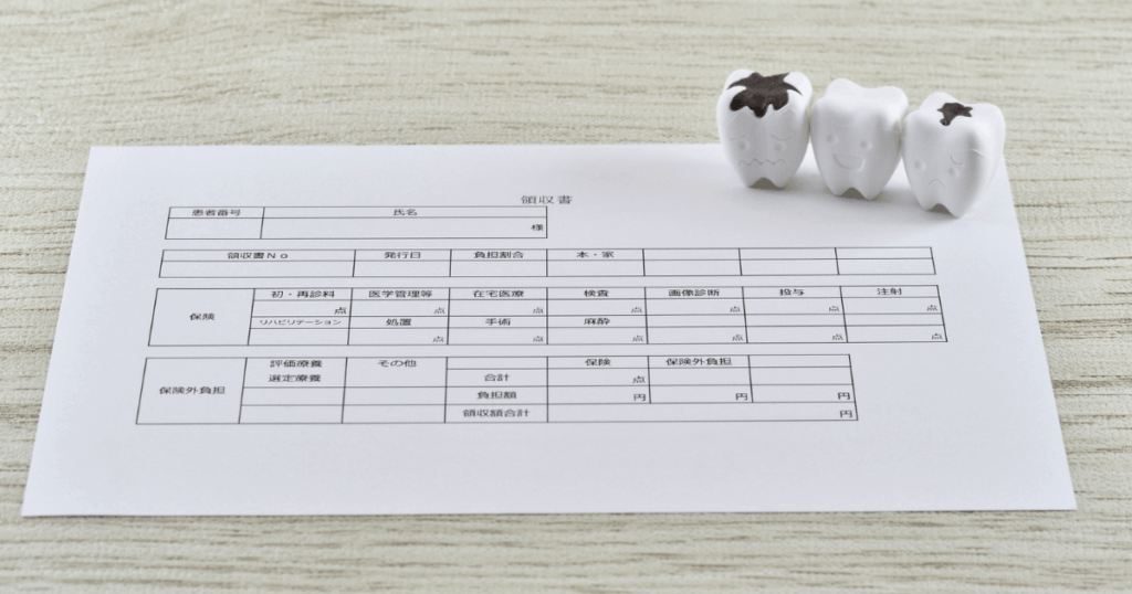 歯周病治療の費用や保険適用の目安をイメージした診療明細と歯の模型