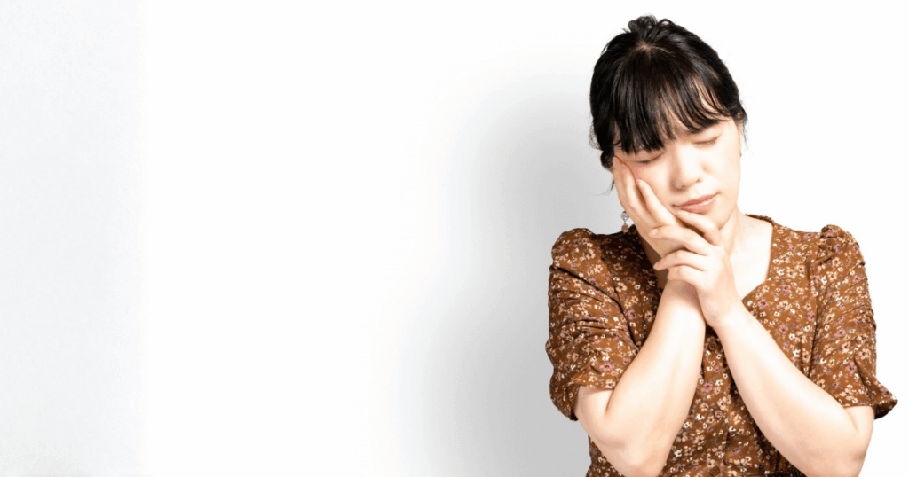 歯や歯ぐきの痛みや不安を感じている女性のイメージ