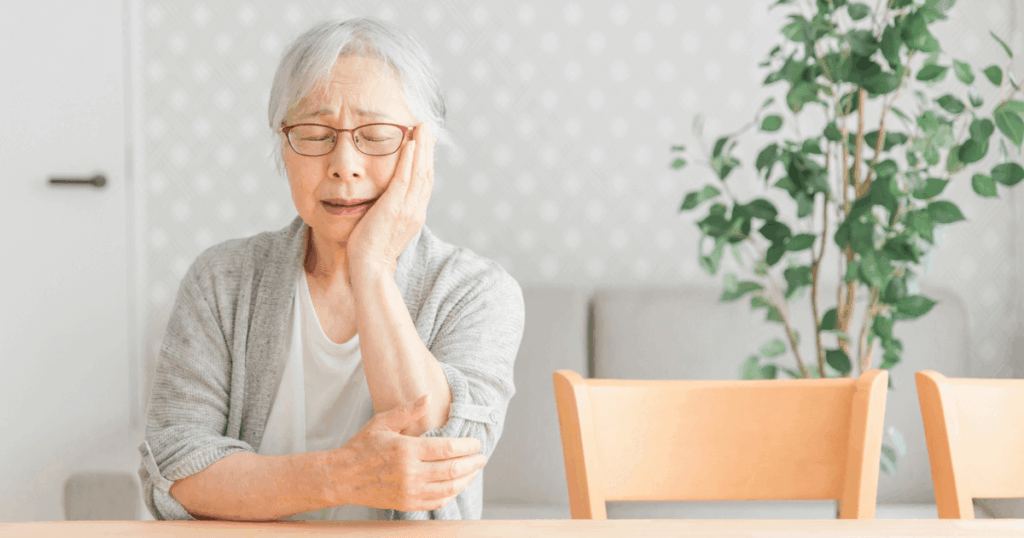 歯ぐきや歯の痛みに悩む高齢女性のイメージ