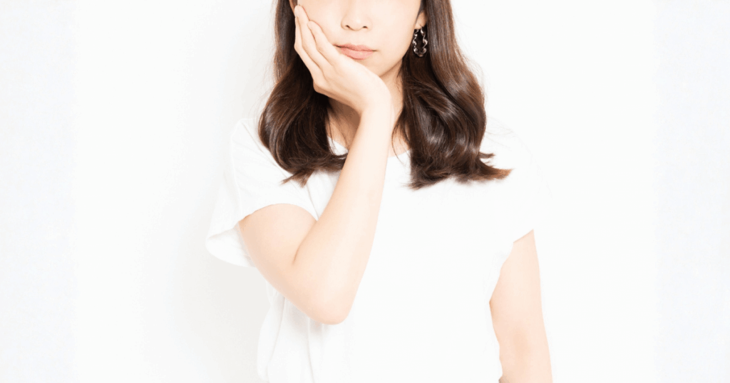 口元に手を当てる女性の写真（歯周病の症状や違和感のイメージ）