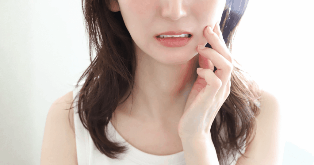 歯ぐきの違和感や痛みなど歯周病の症状を気にしている女性のイメージ