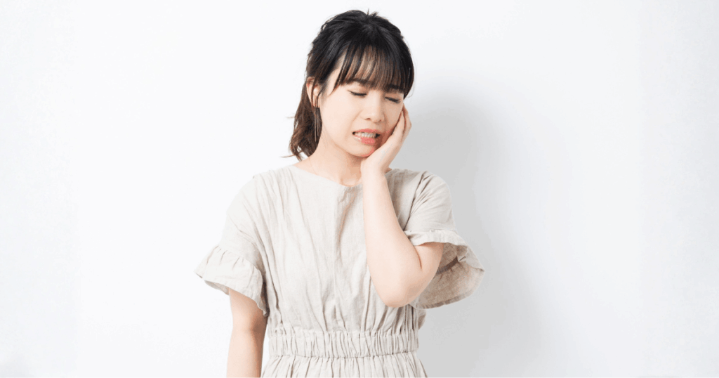 歯周病治療の痛みに不安を感じている患者と説明する歯科医師