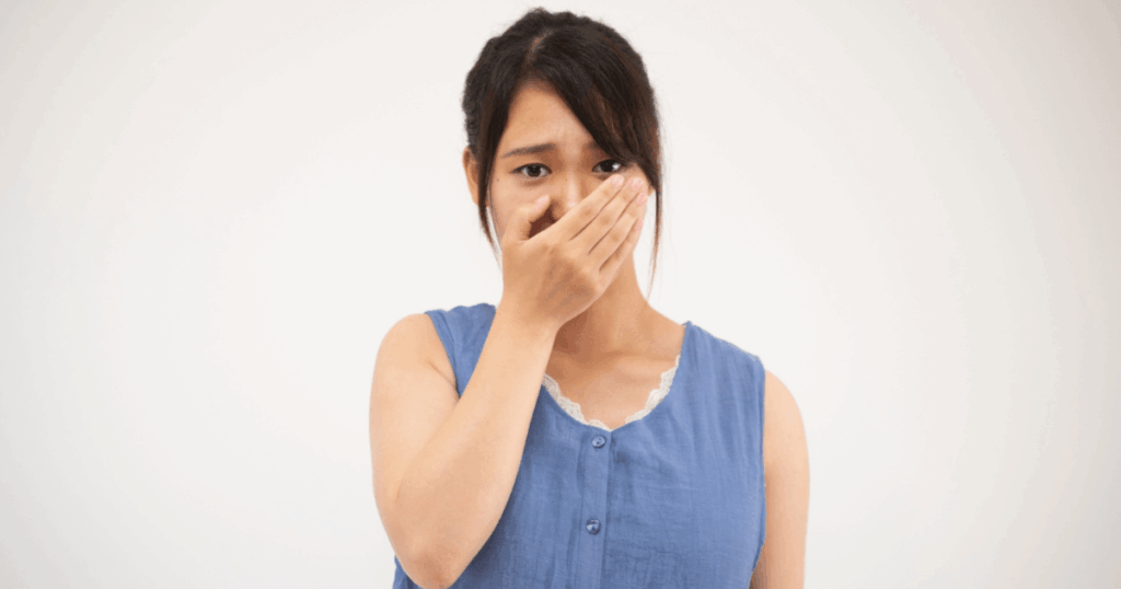 口臭や歯ぐきの違和感を気にする女性のイメージ